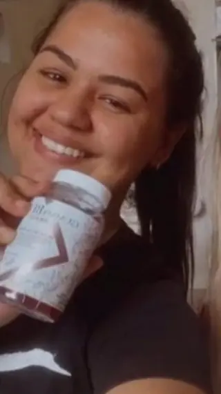 Cliente sorrindo segurando o pote de GummyBe